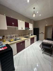 a large kitchen with white and purple cabinets at Appartement fes magnifique in Fez +11 photos