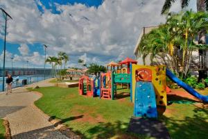 a playground in a park next to the water at Luxurious Flat at Lake Side with lake view. in Brasília