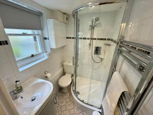 a bathroom with a shower and a toilet and a sink at Dorothy Forster Court in Alnwick