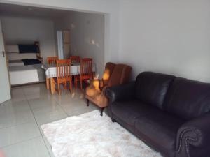 a living room with a black couch and a dining room at Woodpecker Guesthouse Middelburg Mpumalanga in Middelburg +27 photos