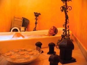 eine Frau, die in einer Badewanne in einem Badezimmer sitzt in der Unterkunft ANETSEDER Landhotel & Lofts in Thyrnau + 37 Fotos