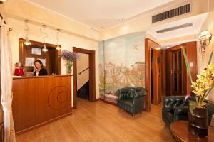 فندق لا فينيس  في روما: امرأة تجلس في مكتب الاستقبال في غرفة