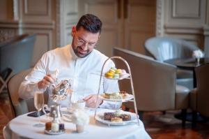 un homme assis à une table avec une assiette de nourriture dans l'établissement Lujoso Penthouse a estrenar en Sofisticado Barrio y Edificio Vista panorámica 100m2 Gimnasio Piscina Lujoso Salon de Fiestas Parking privado con acceso directo al departamento, à Buenos Aires