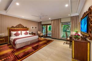una camera con letto king-size e TV a schermo piatto di Mayfair Lagoon a Bhubaneshwar