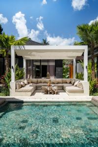 a living room with a couch and a swimming pool at Villa Cocktail and Dreams by BaliSuperHost in Ubud
