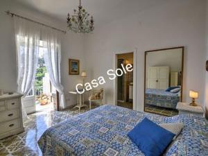 ポジターノにあるCasa Sole Positanoのベッドルーム(青いベッド1台、大きな鏡付)