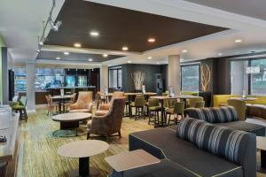 a restaurant with couches and tables and chairs at Courtyard Lafayette Airport in Lafayette