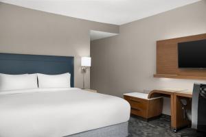 a bedroom with a bed and a desk and a tv at Courtyard Lafayette Airport in Lafayette +30 photos