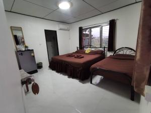 a room with two beds and a mirror in it at Mon Kiang-Dao Resort in Chiang Dao
