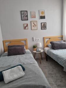 sypialnia z 2 łóżkami i małym stołem w obiekcie Apartment Amelia w mieście La Mata