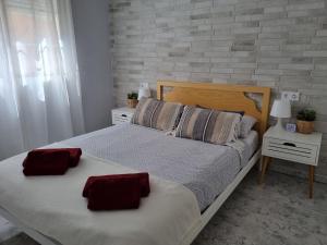 sypialnia z łóżkiem z 2 czerwonymi poduszkami w obiekcie Apartment Amelia w mieście La Mata +35 zdjęć