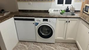 a kitchen with a washing machine and a sink at Casa Blue Lagoon KLIMA FREE WIFI POOL SAT TV in San Miguel de Salinas