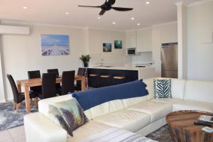 a living room with a white couch and a table at Tradewinds Apartment 4 in South West Rocks