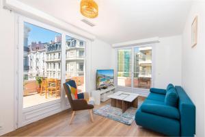 ein Wohnzimmer mit einer blauen Couch und einem Fernseher in der Unterkunft Gloria marris in Menton