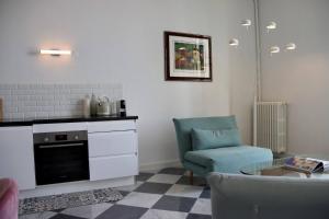 Una sala de estar con una silla y una mesa. en "Le Grand Hotel" Prestigieux et Unique, Vue Mer, en Menton