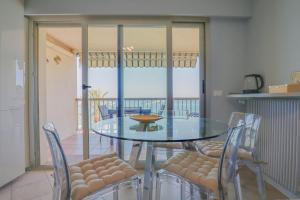 a dining room with a glass table and chairs at "Splendide vue" Front de Mer, Terrasse, Gare train in Roquebrune-Cap-Martin