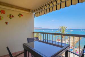 a balcony with a table and a view of the beach at "Splendide vue" Front de Mer, Terrasse, Gare train in Roquebrune-Cap-Martin +20 photos