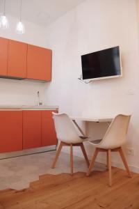 a kitchen with two chairs and a table and a tv at "Le Massena" Plein Centre, Neuf, Proche gare in Menton