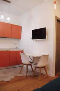 a kitchen with a table and two chairs and a tv on the wall at "Le Massena" Plein Centre, Neuf, Proche gare in Menton