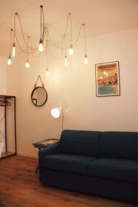 a living room with a blue couch and lights at "Le Massena" Plein Centre, Neuf, Proche gare in Menton +11 photos