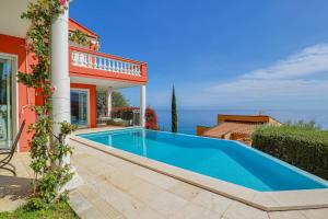 a swimming pool in front of a house at "Le Clos des Guillons" Piscine, Vue imprenable, Parkings in Menton