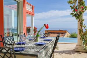 a table with blue plates and glasses on a balcony at "Le Clos des Guillons" Piscine, Vue imprenable, Parkings in Menton