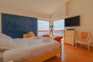 a bedroom with a large bed and a large window at "Le Clos des Guillons" Piscine, Vue imprenable, Parkings in Menton +67 photos