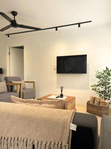 a living room with couches and a flat screen tv at The Paarl Grand in Paarl