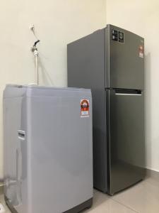 a stainless steel refrigerator sitting in a room at CozyInn Homestay in Kampong Lanjut Manis