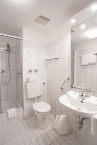 a bathroom with a toilet and a shower and a sink at Hus up Dün in Norderney