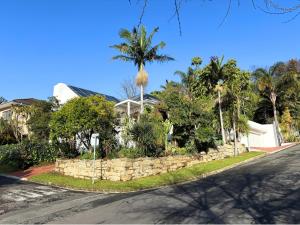 a house with a retaining wall and palm trees at The Paarl Grand in Paarl