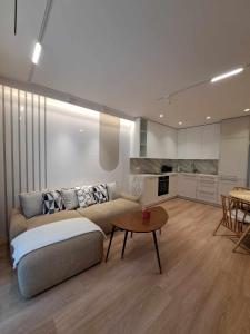 ein Wohnzimmer mit Sofa und Tisch in der Unterkunft Nauji apartamentai Palangoje Nemirsetos parke in Palanga + 7 Fotos