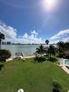 カンクンにあるLagoon-Front House in Hotel Zone Central Location with Easy Access to Top Attractionsのビーチとスイミングプール付きのリゾートの景色を望めます。