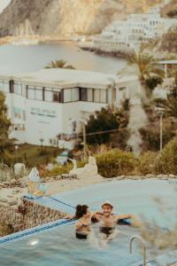 a man and woman in a swimming pool at Hotel Ferdinando Beach & Thermal Spa in Ischia