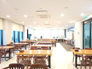 a dining room with tables and chairs and a cafeteria at Sims Hotel in Jeju