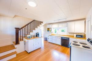 a kitchen with white cabinets and a staircase at Peabody House - 1920s Cottage in Port Angeles