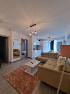 een woonkamer met een bank en een tafel bij Apartament SIMINA ALZ -2 camere in Mamaia Nord – Năvodari