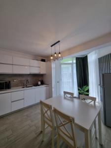 een keuken met een tafel en stoelen in een kamer bij Apartament SIMINA ALZ -2 camere in Mamaia Nord – Năvodari