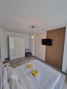 een slaapkamer met een groot wit bed met 2 gele kussens bij Apartament SIMINA ALZ -2 camere in Mamaia Nord – Năvodari +19 foto's