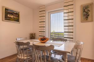 a dining room with a table and chairs and a window at Holiday house VilAna with Jacuzzi - Happy Rentals in Puconci