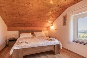 a bedroom with a bed with a wooden ceiling at Holiday house VilAna with Jacuzzi - Happy Rentals in Puconci +20 photos