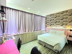 a hotel room with a bed and a window at 191 Hotel in Taoyuan