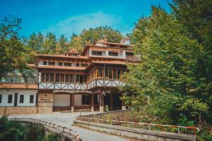a large building with trees in front of it at Hotel Bozhentsi in Chernevtsi