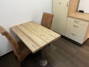a wooden table and two chairs in a room at 1 Zimmer Ferienwohnung in Essen in Essen +5 photos