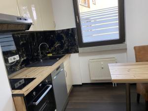 a kitchen with a sink and a wooden table at 1 Zimmer Ferienwohnung in Essen in Essen