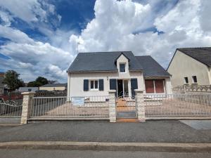ein weißes Haus mit einem Zaun davor in der Unterkunft Maison de vacances 400 m de la plage et du port de la Turballe in La Turballe