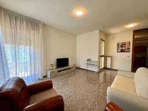 a living room with a couch and a tv at Casa Aurelio 2 min dall'ospedale in Negrar