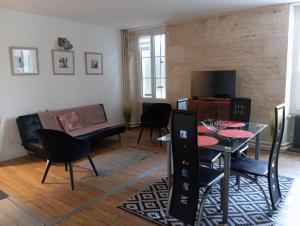 a living room with a table and a couch at Au bord de l'eau COULON in Coulon