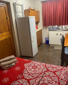 a kitchen with a refrigerator and a table with a red rug at Rivier-Plesier Cottage at Riggton River Farm in Bonnievale