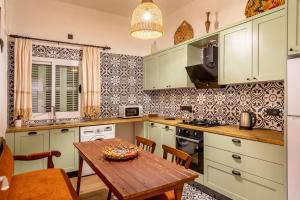 a kitchen with green cabinets and a wooden table at Diamante Guest House-Ground in Famagusta